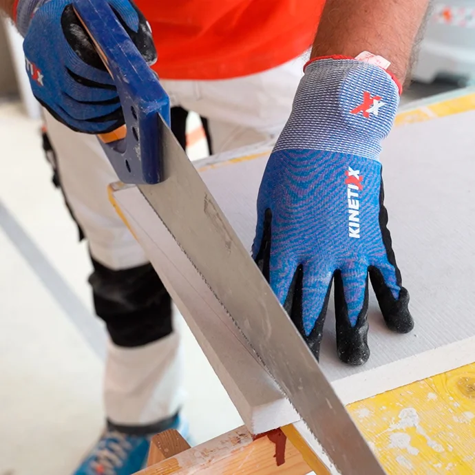 Person s&auml;gt den Kalziumsilikatplatte Anschlusskeil mit einer Hands&auml;ge zu.