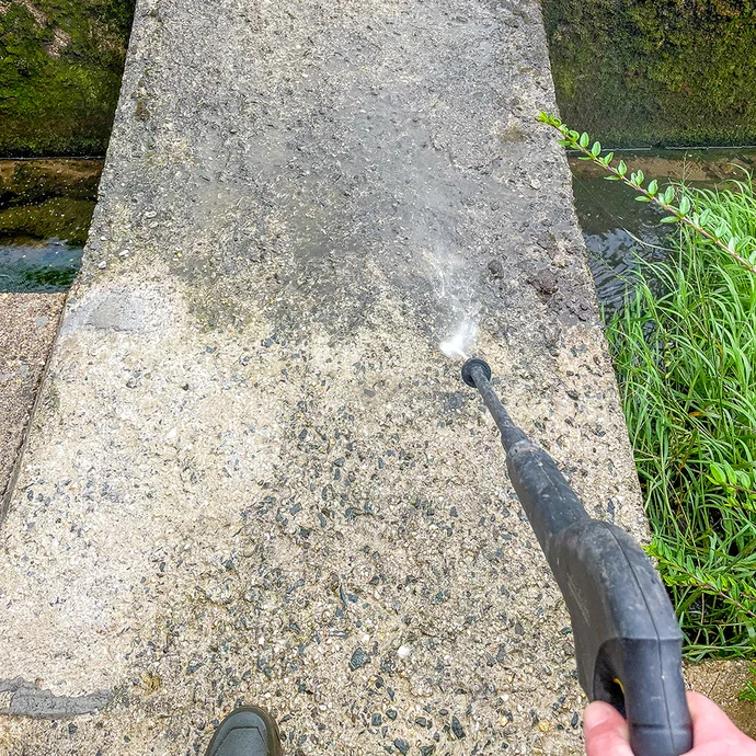Betonuntergrund wird mit einem Hochdruckreiniger gründlich gereinigt, um Schmutz und lose Bestandteile vor der Weiterverarbeitung zu entfernen.