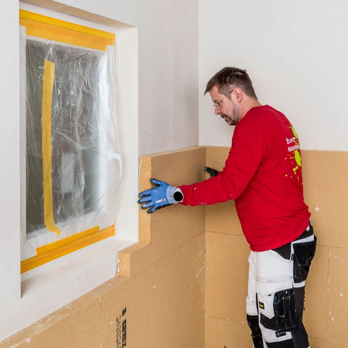 Die zugeschnittene D&auml;mmplatte in L-Form f&uuml;r das Fenster wird mit Klebem&ouml;rtel versehen und kr&auml;ftig an die Wand geklebt. Baumit Selbermachen Anleitung Innenend&auml;mmung - geklebtes Mauerwerk.