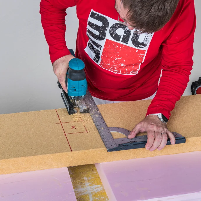 Heimwerker schneidet Aussparung f&uuml;r Steckdose in Baumit Holzfaserd&auml;mmplatte mit Stichs&auml;ge und Winkel zu &ndash; D&auml;mmplatte passgenau f&uuml;r Innend&auml;mmungsdose zuschneiden, Baumit Selbermachen Anleitung.