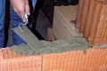 Baumit Metselmortel wordt op de baksteen aangebracht en er wordt een muur gebouwd.