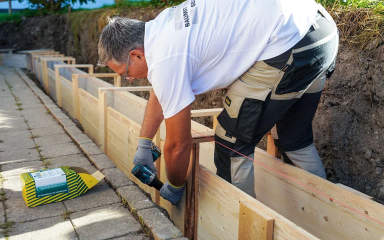 Die Schalungselemente werden miteinander mit einem überlappendem Brett verschraubt. Das Brett sollte mindesten 5 cm überlappen.