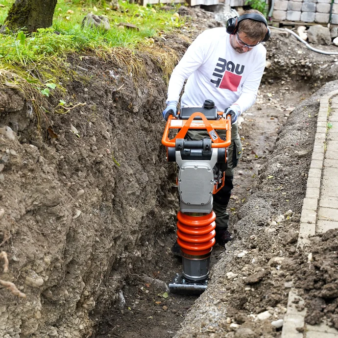 Verdichte das Erdreich in der Baugrube mit einer Rüttelplatte oder einem Stampfer bzw. Verdichter.